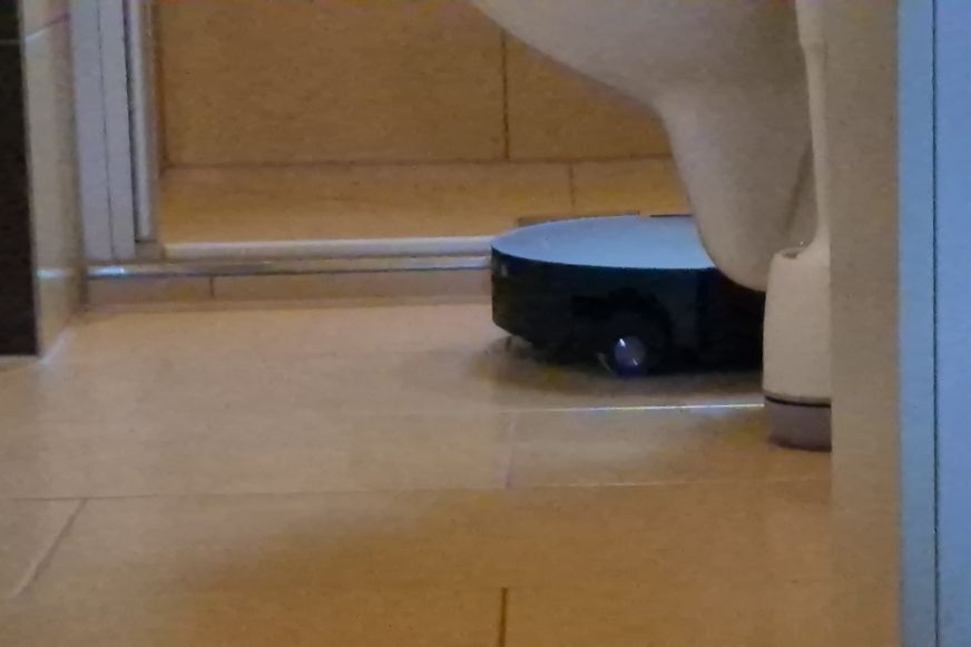 Roborock Saros 20 Flow mit eingefahrenem Laserturm unter einem Sideboard